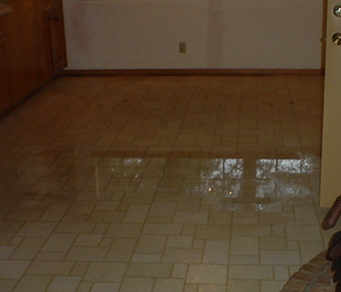 Kitchen tile with pool of water after a leak.