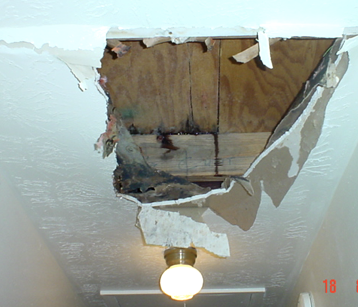 Hole in a ceiling due to water damage.