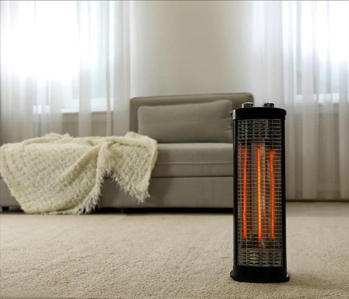 Modern electric halogen heater on floor in living room interior